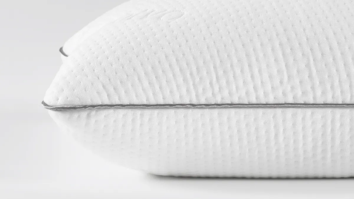 Side profile of the Saatva Memory Foam Pillow showing loft